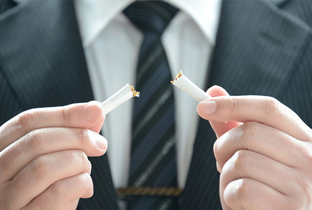 折れている煙草を手で持っている男性